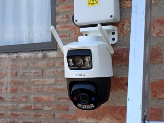 Cámara IP WiFi Imou motorizada instalada sobre la pared de ladrillo de una vivienda