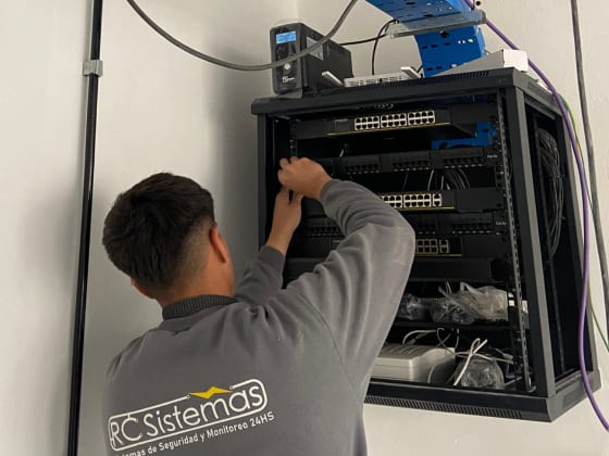 Técnico de RC Sistemas trabajando sobre un rack mural con switches y pacheras